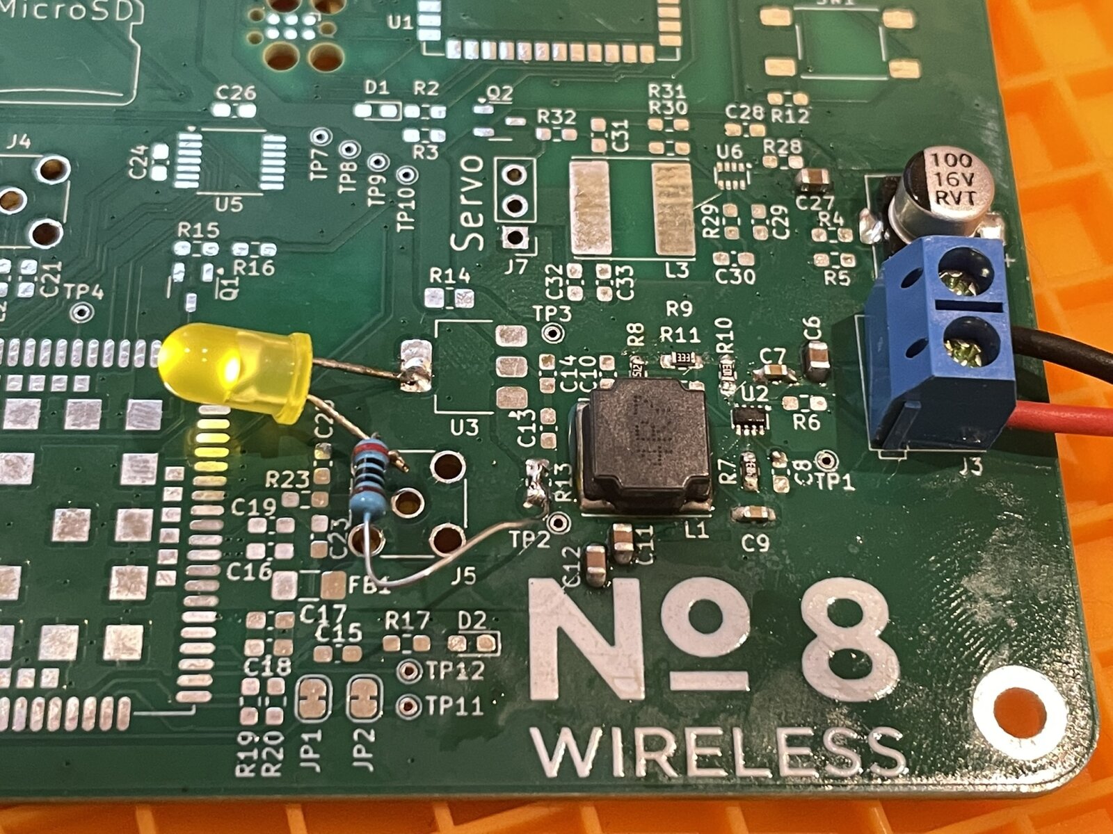 With
the power supply populated, a through-hole LED and resistor are tacked on, and
illuminated with the board powered up